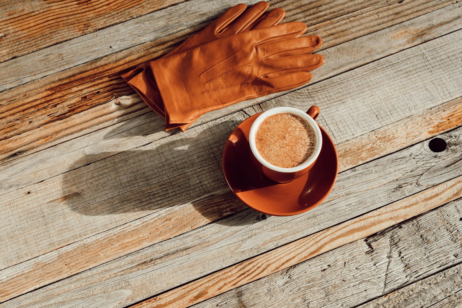 Pair of brown leather work gloves photographed on a neutral background